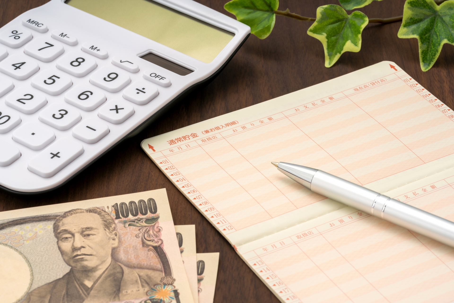 電卓と通帳で葬儀費用を確認する様子